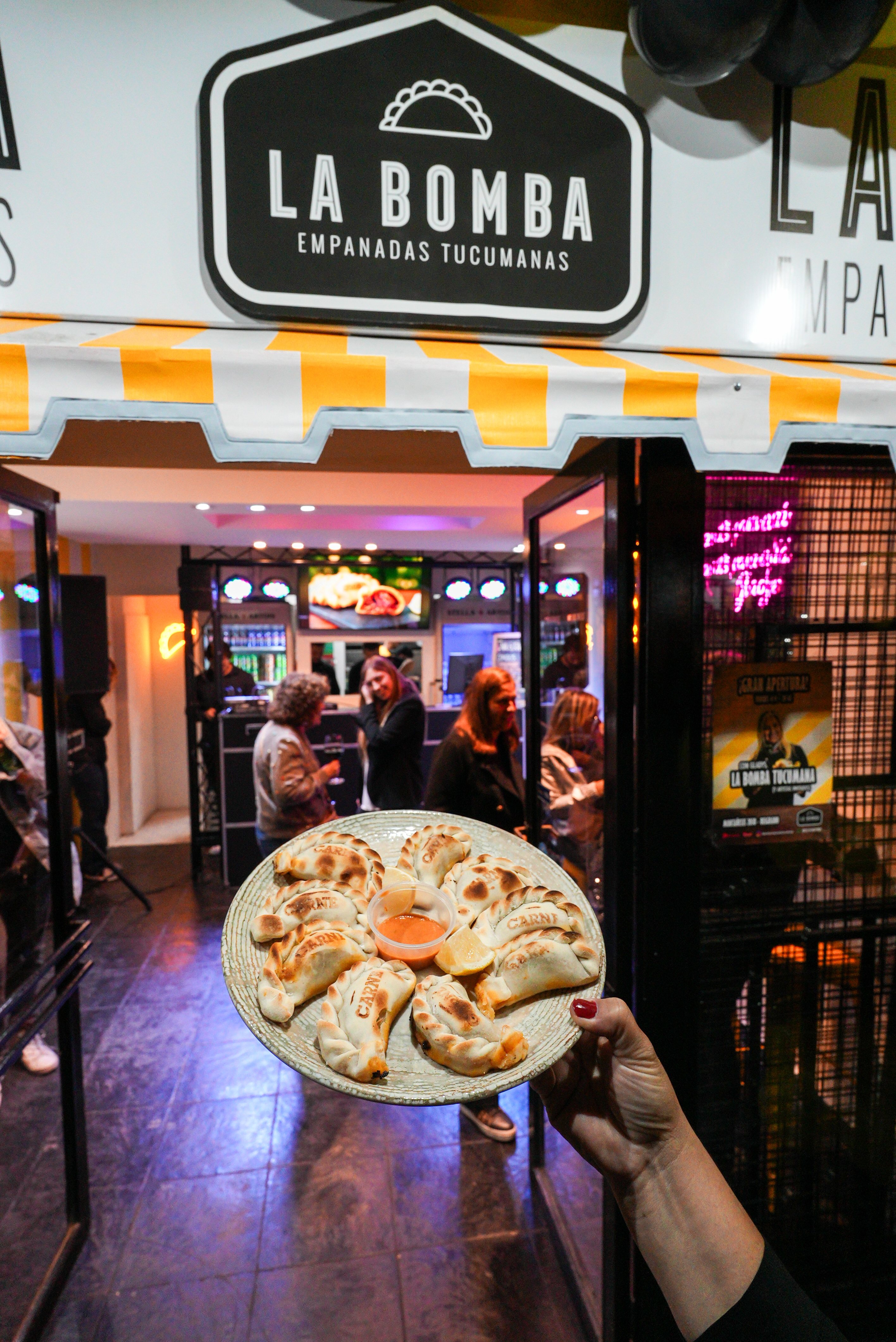Plato de empanadas frente a la entrada de La Bomba Empanadas Tucumanas